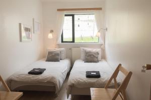 SúðavíkSudavik guesthouse的小型客房 - 带2张床和窗户