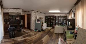 堺市Nakagawa's Cozy House的客厅铺有木地板,配有冰箱。