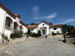 曼瓜尔迪Solar de Almeidinha的前面有石头车道的大型白色房屋