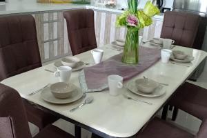 瓜拉雪兰戈Manee Home Kota Damansara的一张桌子,上面有盘子和花瓶
