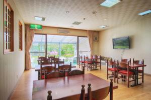 山中湖村昆索酒店的一间带桌椅和电视的用餐室