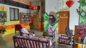 马六甲老城旅馆的一间设有椅子的房间和墙上的绘画