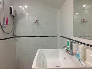 沙美岛日出海景度假村的白色的浴室设有水槽和淋浴。