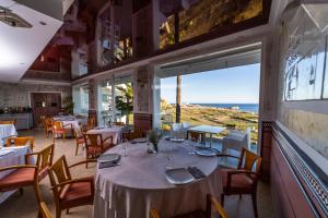 萨各夫雷纳Hotel Salambina的一间带桌椅的海景餐厅