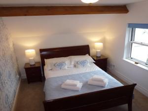 Bassenthwaite LakeMeadowside Cottage的一间卧室配有一张床,上面有两条毛巾