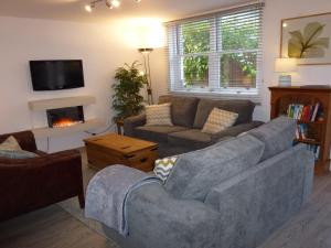 Bassenthwaite LakeMeadowside Cottage的带沙发和壁炉的客厅