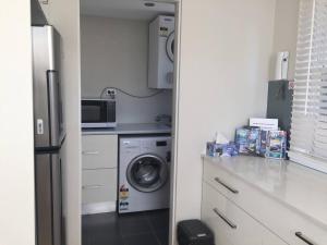 克罗纳拉Cronulla Beach Break的厨房配有冰箱和洗衣机。
