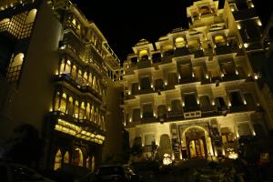 乌代浦乌代浦可斯酒店的一座白色的大建筑,晚上有灯光
