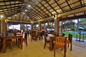本托塔Sea Rock Villa的餐厅设有桌椅,享有高尔夫球场的景色
