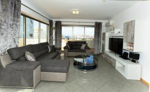 波尔蒂芒Exclusive Luxury Apartments in Oceano Atlantico Complex的带沙发和电视的客厅