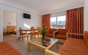 哈马马特Le Corail Appart'Hotel Yasmine Hammamet的客厅配有沙发和桌子