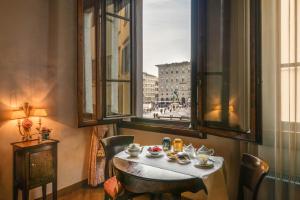 佛罗伦萨执政团广场德埃博卡居所酒店的市景客房内的一张桌子