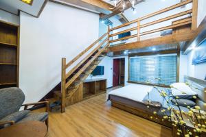 黟县宏村瑞云精品酒店的阁楼卧室设有一张床和一个楼梯