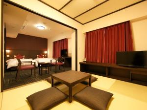 和歌山多美迎PREMIUM和歌山天然温泉酒店的客厅设有一张床和一张桌子