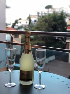 罗列特海岸Apartament Lloret de Mar with terrace的桌子上放有一瓶葡萄酒和两杯酒