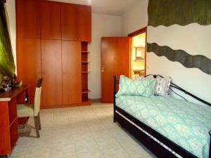帕拉代西翁Cozy apartment in Paradisi的一间卧室配有一张床、一张书桌和橱柜。
