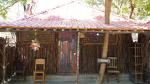 迪亚尼海滩Soul Breeze Backpackers Diani的一个小小屋,配有椅子和标志