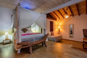 伊利亚贝拉Hotel Vila Kebaya的一间卧室配有一张天蓬床和窗户