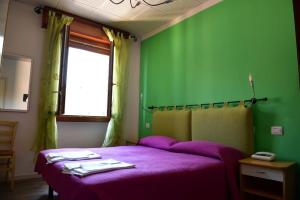 贝尔蒂诺罗Albergo Colonna的一间卧室配有一张带绿色墙壁的紫色床