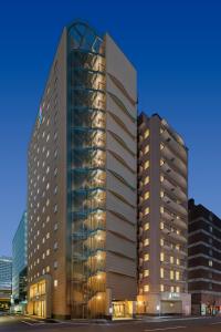 大阪SARASA HOTEL Shin-Osaka的一座高大的建筑,城市里螺旋形