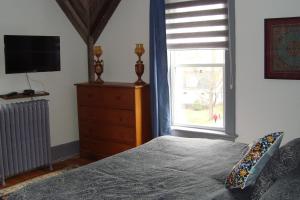 梅戈格博伊斯住宿加早餐酒店的一间卧室配有一张床、一个梳妆台和一扇窗户。
