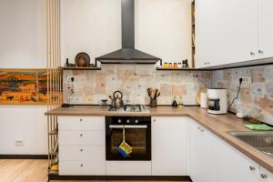 埃里温RIS Dalma Collection Yerevan的厨房配有白色橱柜和炉灶烤箱。