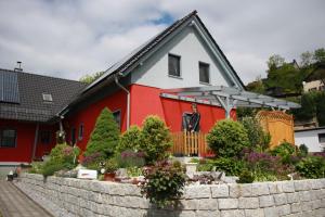 巴特尚道Fewo Ehrlich Sächs. Schweiz的红色和白色的房子,有一面挡墙