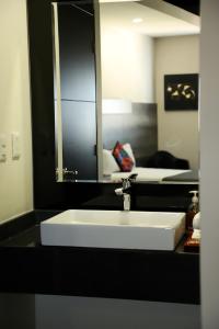库利亚坎Homesuites Malecon的浴室设有白色水槽和镜子