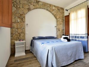 洛特佐拉伊Villa Menhir的一间卧室设有一张床和石墙