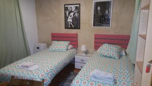 赫雷斯-德拉弗龙特拉Villa Marina的卧室配有两张床,墙上挂有两张照片