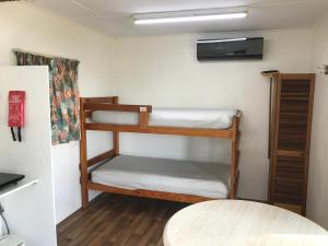 Meningie艾伯特湖大篷车公园酒店的客房设有两张双层床和一张桌子。
