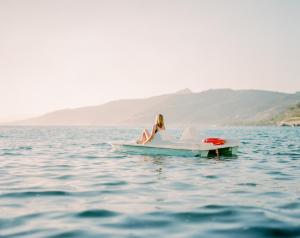 切法卢蓝湾酒店的坐在水中的船上的女人