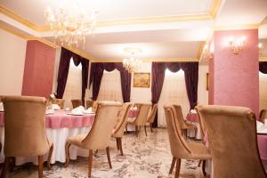 曼加利亚Royal Boutique Mangalia Breeze的一间带桌椅和吊灯的用餐室