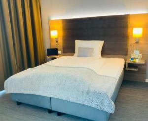 雷马根StadtHotel ARTE的一张大床,位于酒店带两盏灯的房间