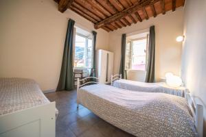 马萨Ostello Palazzo Nizza的一间卧室设有两张床和两个窗户。