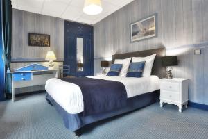 La CoquilleLogis Hôtel-Restaurant Les Voyageurs的大卧室设有一张带蓝色墙壁的大床