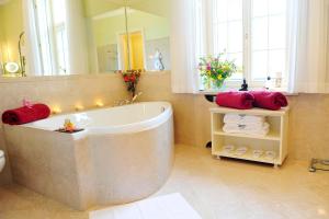 库塔斯海尔特莱卡斯特酒店的一间带大浴缸和大镜子的浴室