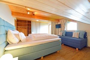 沃尔特湖畔韦尔登Pleschinhof的一间卧室配有一张床和一张蓝色的沙发