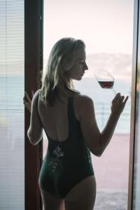 切法卢蓝湾酒店的一位穿着比基尼的女人,拿着一杯葡萄酒