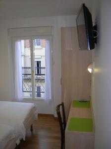 巴黎达尔塞酒店的一间卧室配有一张床、一张书桌和一个窗户。
