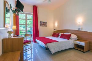 Balestrino卡德伯纳酒店的一间卧室配有一张床、一张书桌和一个窗户。