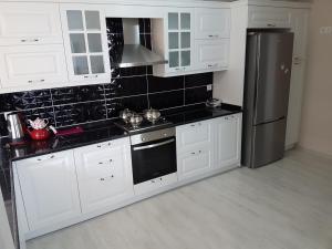 特拉布宗Fursan Apart My Doğa的厨房配有白色橱柜和不锈钢冰箱