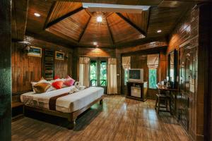 奥南海滩富帕拗喃Spa度假酒店的卧室配有一张床铺,位于带木墙的房间内