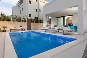 穆泰尔岛Luxury Apartment La Mer的一个带椅子的游泳池以及一座房子