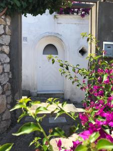 卡普里Casa Maddy的白色的门,前面有紫色的花朵