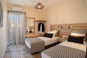 普拉基亚斯Plakias Family Apartment的酒店客房,设有两张床和镜子
