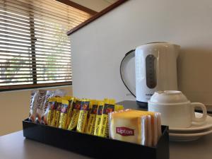 凯恩斯热带海湾乡村酒店的一张桌子,上面放着一盒谷物和咖啡壶
