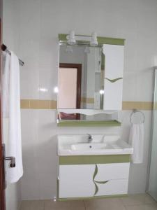 ButareHôtel Maisons-Sifa的白色的浴室设有水槽和镜子