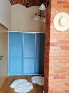 库雷萨雷Stylish apartment with sauna的一间设有蓝色百叶窗和砖墙的房间