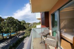 利尼亚诺萨比亚多罗丹尼尔酒店的阳台配有床和桌椅